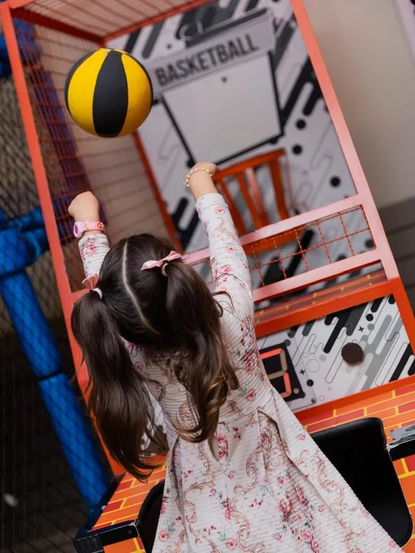 Menina acertando a cesta no basquete do parque